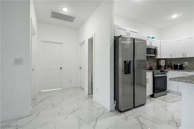 kitchen with marble finish floor, white cabinetry, stainless steel appliances, decorative backsplash, and light stone countertops