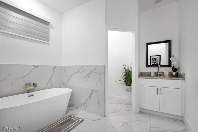 bathroom featuring vanity, a soaking tub, and marble finish floor