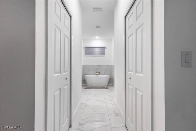 corridor featuring a wainscoted wall, visible vents, recessed lighting, tile walls, and marble finish floor