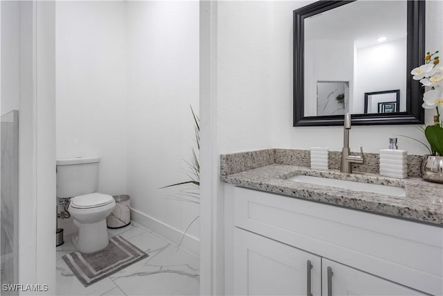 bathroom with marble finish floor, toilet, vanity, and baseboards