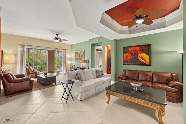 tiled living room featuring a raised ceiling, ceiling fan, and ornamental molding