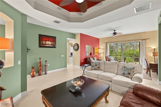 living room with visible vents, a tray ceiling, and a ceiling fan