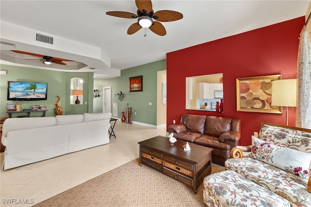 tiled living area featuring visible vents, baseboards, and ceiling fan