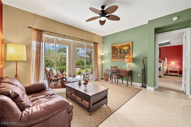 living area featuring light tile patterned floors, baseboards, and ceiling fan