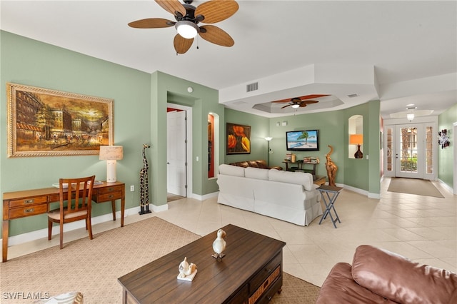 living area featuring tile patterned flooring, baseboards, and ceiling fan