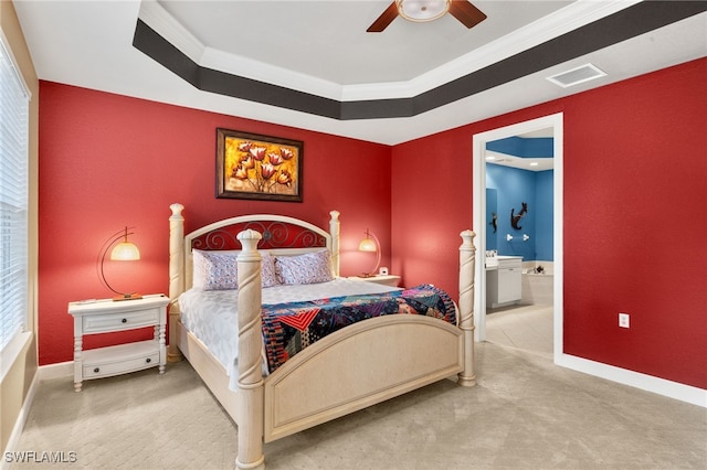 carpeted bedroom with connected bathroom, a raised ceiling, and baseboards