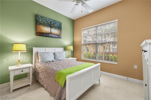 carpeted bedroom with ceiling fan and baseboards