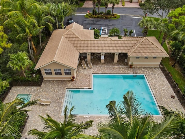 community pool with a patio and fence