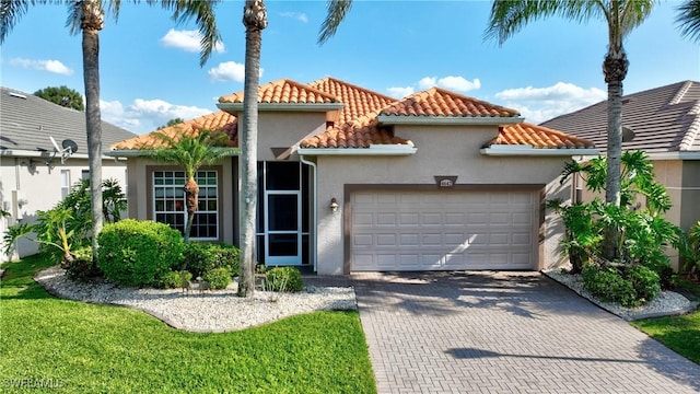 mediterranean / spanish-style home with stucco siding, a tiled roof, decorative driveway, and a garage