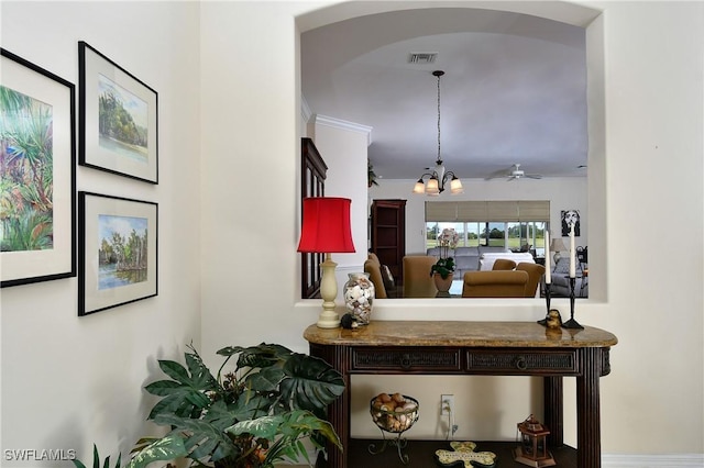 interior details featuring ceiling fan with notable chandelier, crown molding, arched walkways, and visible vents