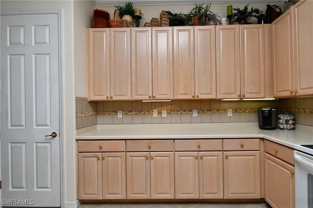 kitchen with light brown cabinetry, backsplash, and light countertops