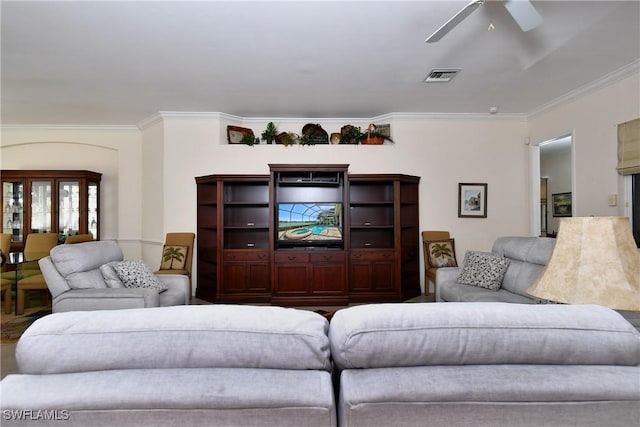 living room with ornamental molding, visible vents, and ceiling fan