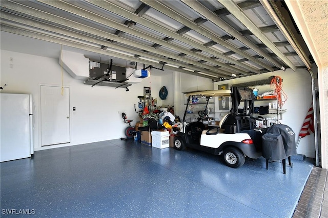 garage with a garage door opener and freestanding refrigerator