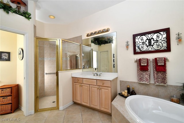 bathroom featuring tile patterned floors, a stall shower, a bath, and vanity