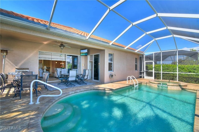 view of swimming pool featuring glass enclosure, a ceiling fan, outdoor dining area, a pool with connected hot tub, and a patio area