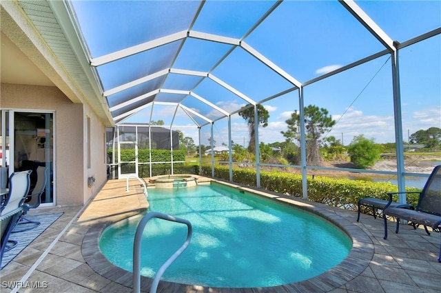 view of swimming pool featuring glass enclosure, a patio, and a pool with connected hot tub