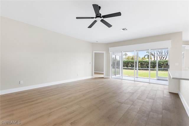 unfurnished living room featuring baseboards, a ceiling fan, wood finished floors, and visible vents
