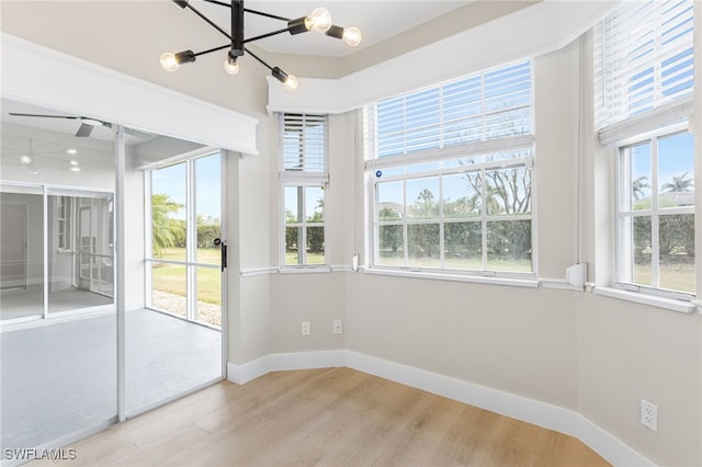 unfurnished sunroom with plenty of natural light and a notable chandelier
