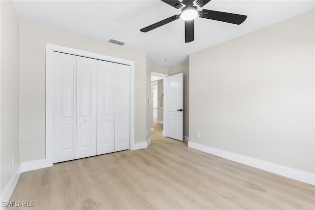 unfurnished bedroom with a ceiling fan, visible vents, baseboards, a closet, and light wood-style floors