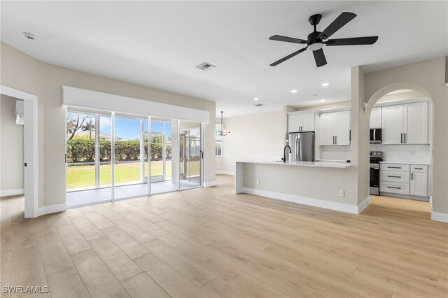 unfurnished living room featuring ceiling fan, light wood-style flooring, and visible vents
