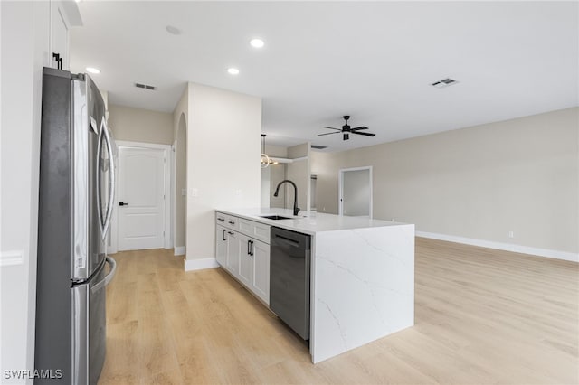 kitchen with freestanding refrigerator, visible vents, a sink, and dishwasher