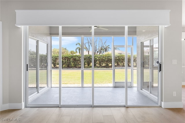 entryway featuring baseboards, a ceiling fan, and wood finished floors