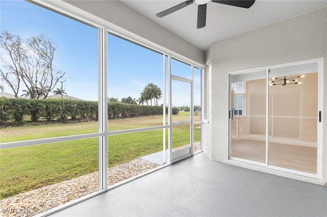 unfurnished sunroom featuring a ceiling fan