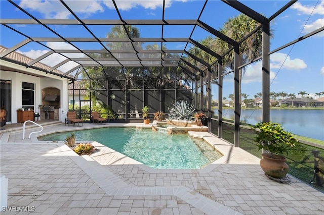 view of pool with glass enclosure, a patio, a water view, and an outdoor kitchen