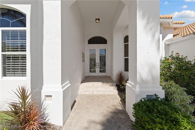 doorway to property featuring stucco siding and french doors