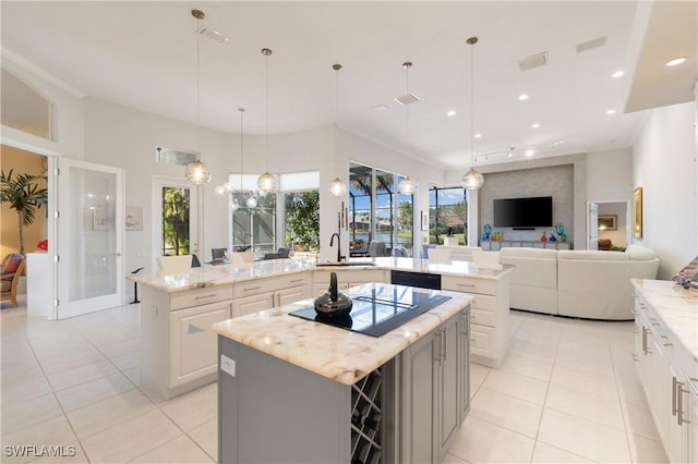 kitchen featuring recessed lighting, a sink, a large island, black appliances, and open floor plan