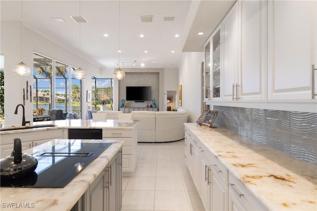 kitchen featuring light tile patterned flooring, a sink, black appliances, glass insert cabinets, and backsplash