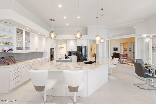 kitchen featuring tasteful backsplash, black appliances, crown molding, and a sink