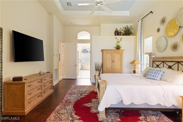 bedroom with a tray ceiling, crown molding, visible vents, and dark wood-type flooring