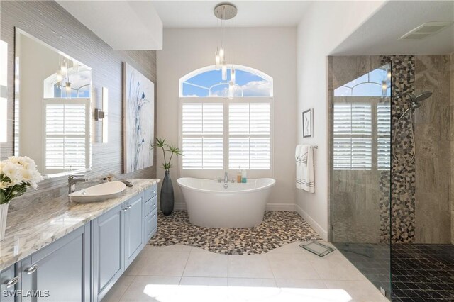 full bathroom with tile patterned floors, a soaking tub, walk in shower, and vanity