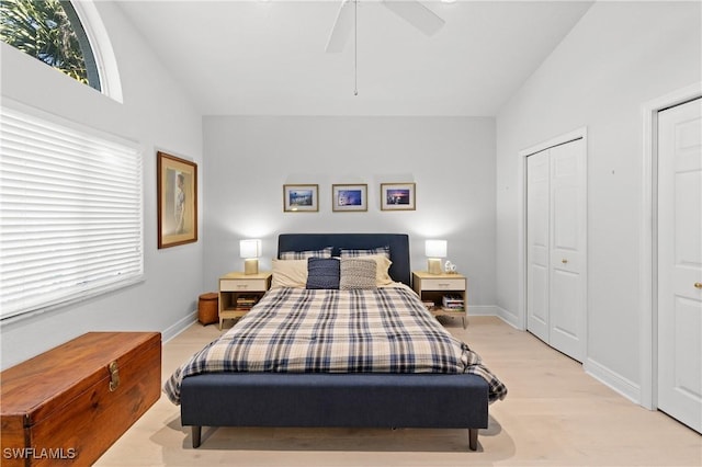 bedroom featuring lofted ceiling, light wood-style floors, baseboards, and ceiling fan