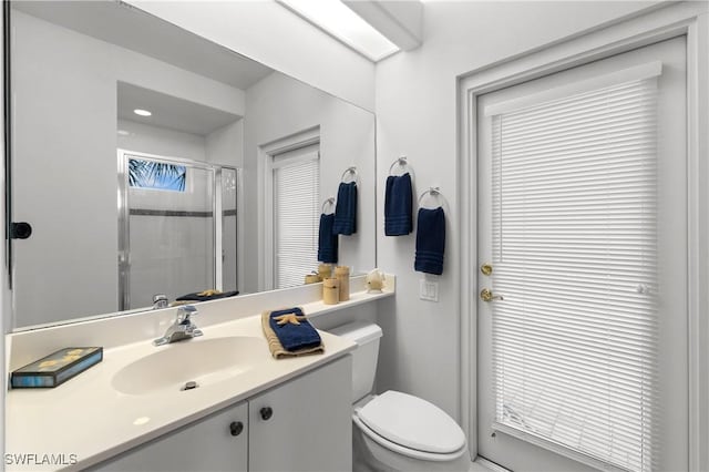 full bathroom with a shower stall, toilet, and vanity