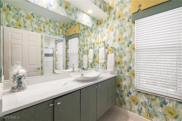 bathroom featuring tile patterned flooring, baseboards, vanity, and wallpapered walls