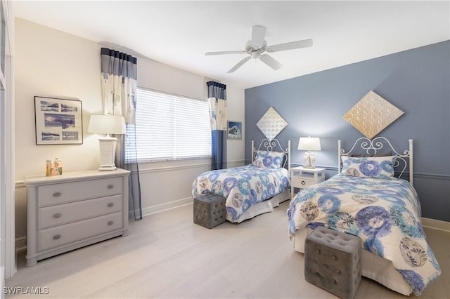 bedroom featuring ceiling fan, baseboards, and wood finished floors