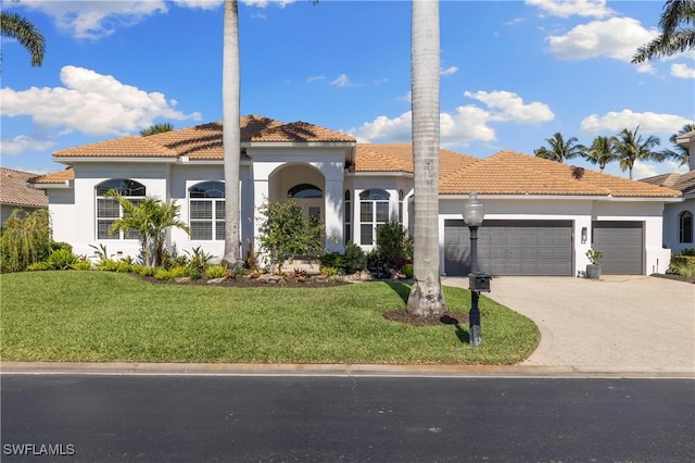 mediterranean / spanish-style house with a tiled roof, stucco siding, an attached garage, and a front lawn