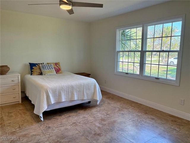 bedroom with multiple windows, a ceiling fan, and baseboards