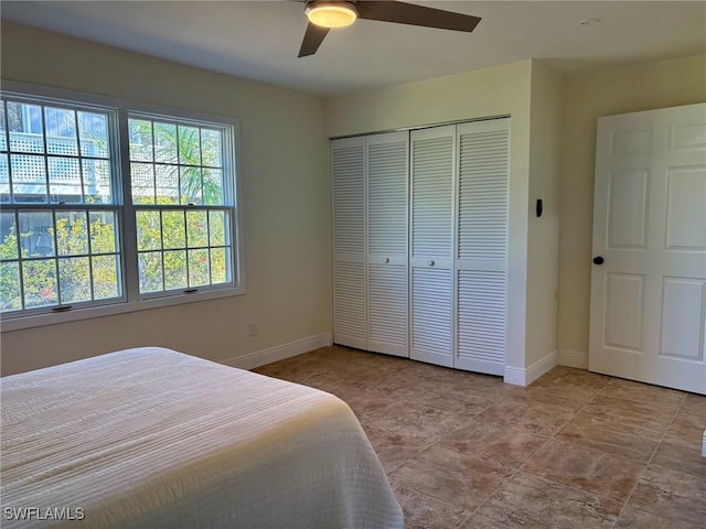 bedroom with a closet, baseboards, and a ceiling fan