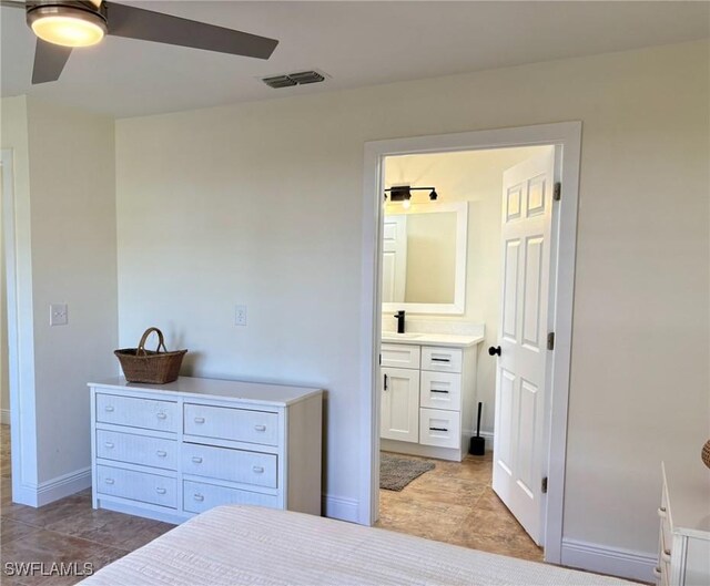 bedroom with a ceiling fan, baseboards, visible vents, a sink, and connected bathroom