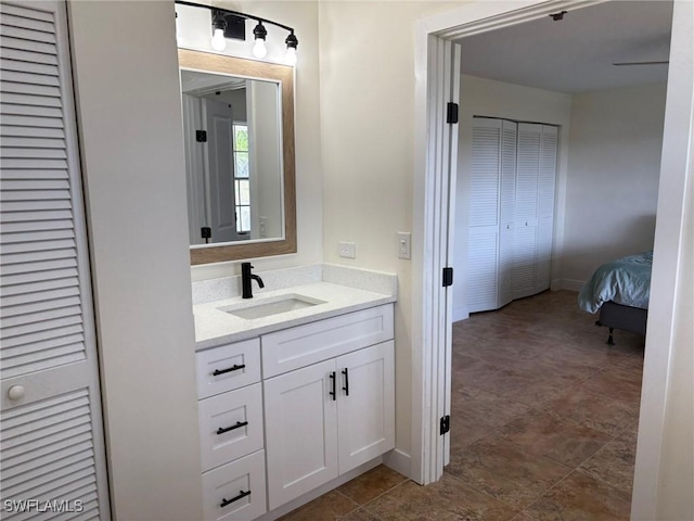 bathroom featuring vanity, a closet, and baseboards