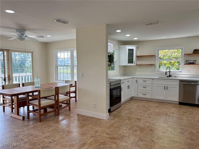 kitchen featuring plenty of natural light, open shelves, visible vents, appliances with stainless steel finishes, and a sink