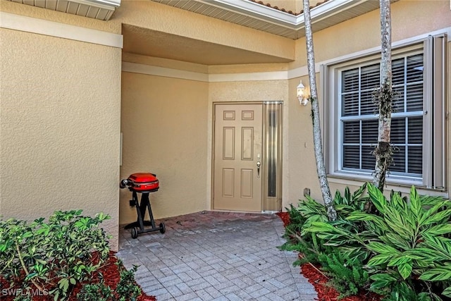 doorway to property with a patio area and stucco siding