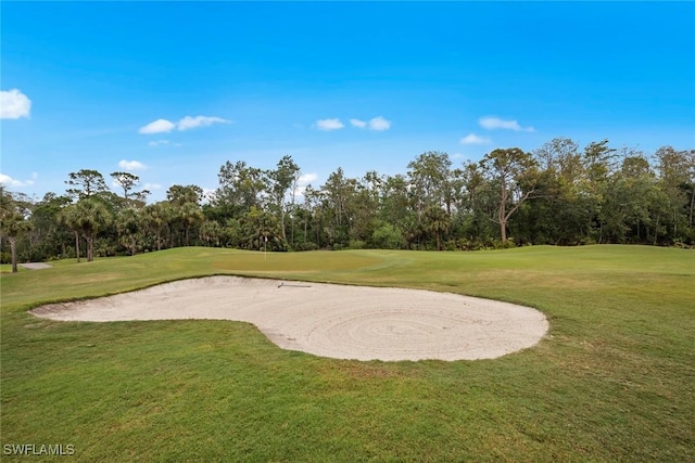 view of community with view of golf course and a lawn