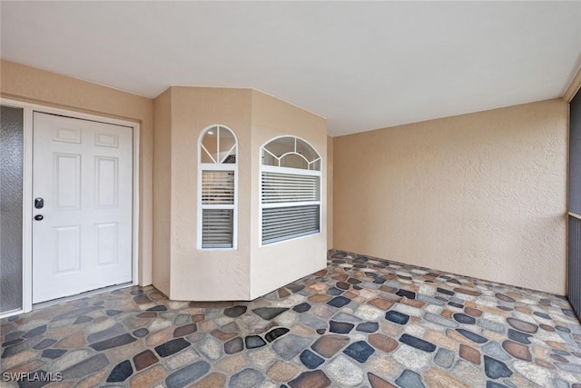 doorway to property featuring stucco siding