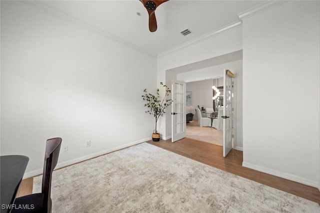 interior space featuring visible vents, baseboards, wood finished floors, and ornamental molding