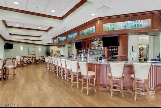 bar with recessed lighting, light wood-type flooring, crown molding, and wet bar