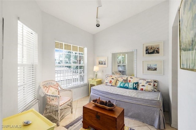 tiled bedroom featuring lofted ceiling and rail lighting